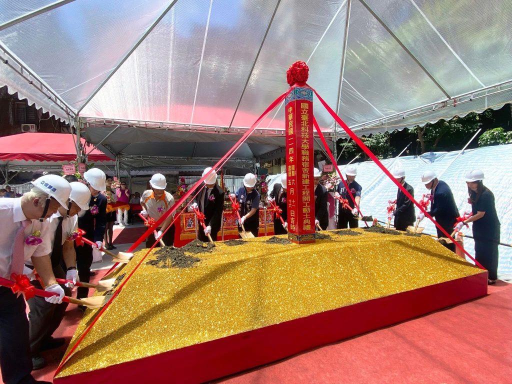 國立臺北科技大學職務宿舍動土儀式中，貴賓共同將土壤鋪入象徵金色土地台上。